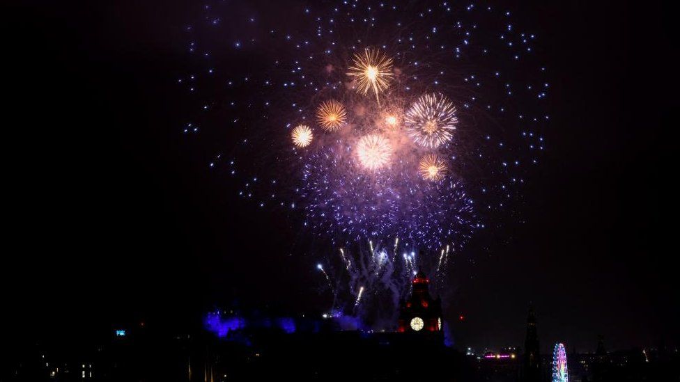 Fireworks light up the sky over Edinburgh Castle and the Balmoral Hotel Clock to mark the New Year