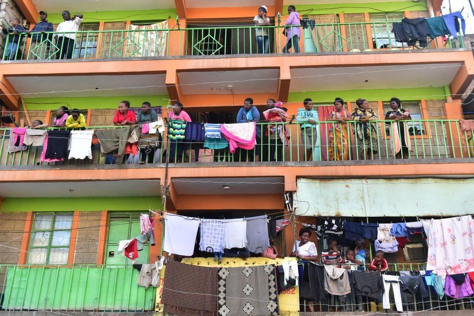 People stand on their balconies and look out.