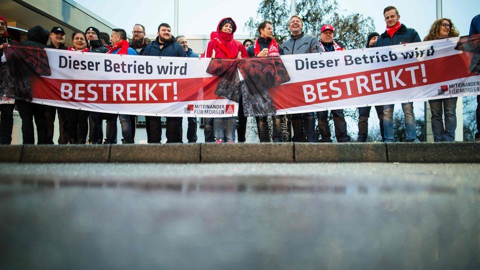 Members of the metalworkers" and electrical industry union (IG Metall) protest during a warning strike
