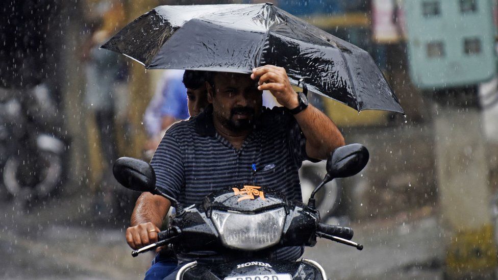 Commuters make their way during a monsoon rainfall in Amritsar on August 1, 2022.