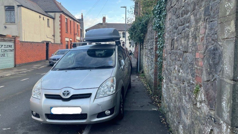 Car parked on the pavement blocking passage