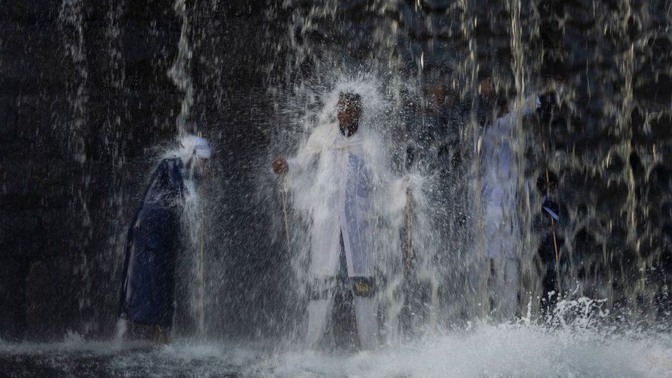 Pilgrims stand under a waterfall as they cleanse themselves of evil spirits during a Sunday morning ritual at a waterfall on the Braamfontein Spruit river in Johannesburg, South Africa, 03 March 2024