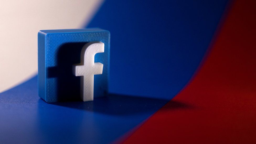 An image of the facebook logo and the russian flag