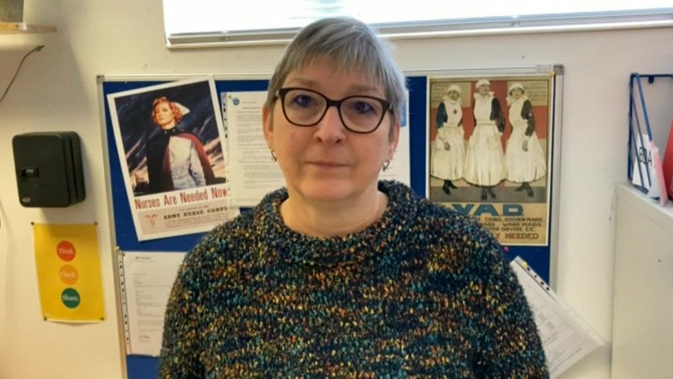 Angela Dawson care manager in Bradford on Avon in front of retro nursing recruitment posters