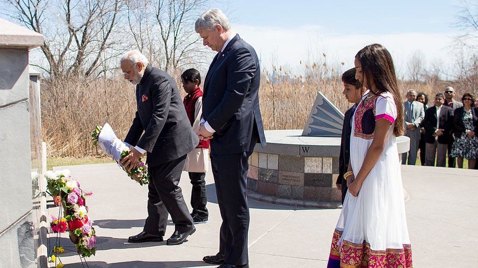 Canadian Prime Minister Stephen Harper (C) leaves a wreath with Indian Prime Minister Narendra Modi (L) during a ceremony at the Toronto memorial to the 1985 Air India bombing,on April 16, 2015 in Toronto, Ontario.
