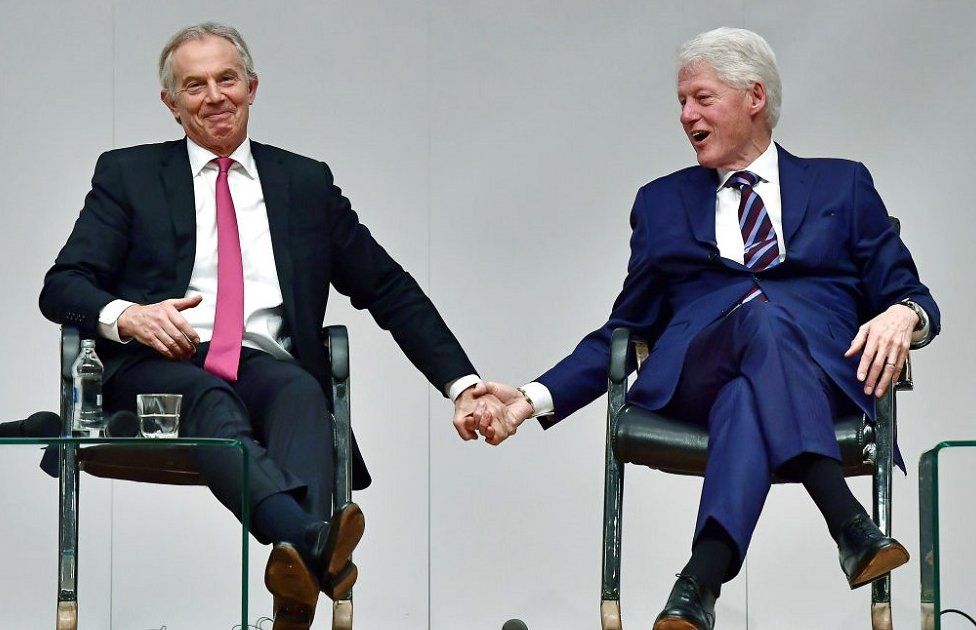 Tony blair holding hands with Bill Clinton