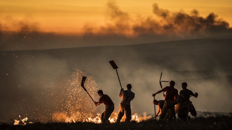 Men beating down the flames