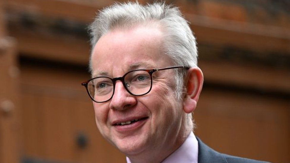 Michael Gove smiles as he looks away from the camera