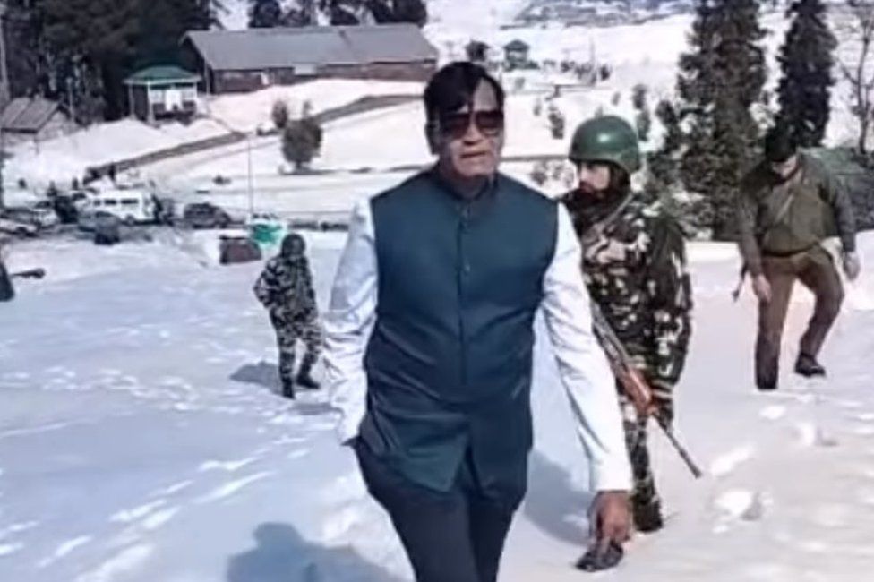A screenshot from a video showing Patel with a security cover in Gulmarg