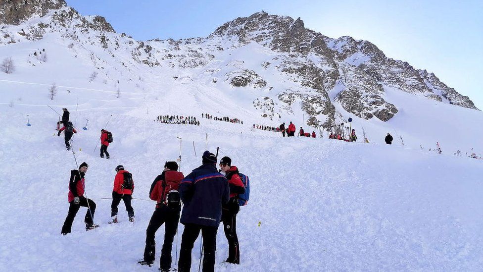 Спасатели стоят на леднике Реттенбах недалеко от Зельдена в Тироле, Австрия, в субботу после того, как пять любителей зимних видов спорта были спасены после схода лавины.