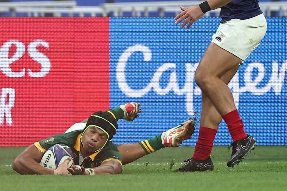 South Africa's wing Kurt-Lee Arendse (L) dives past France's full-back Thomas Ramos to score a try during the France 2023 Rugby World Cup quarter-final match between France and South Africa at the Stade de France in Saint-Denis, on the outskirts of Paris, on October 15, 2023.
