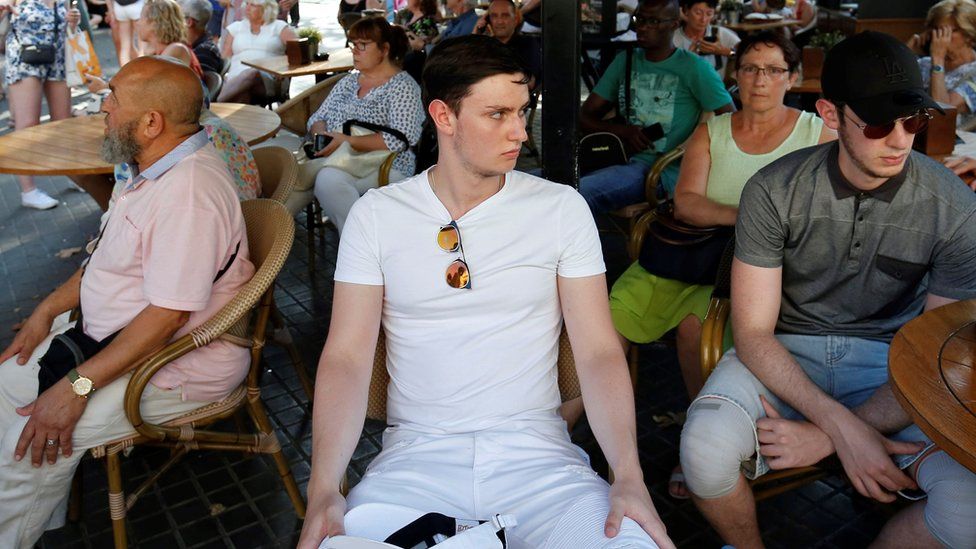 People wait at a cafe terrace after the attack