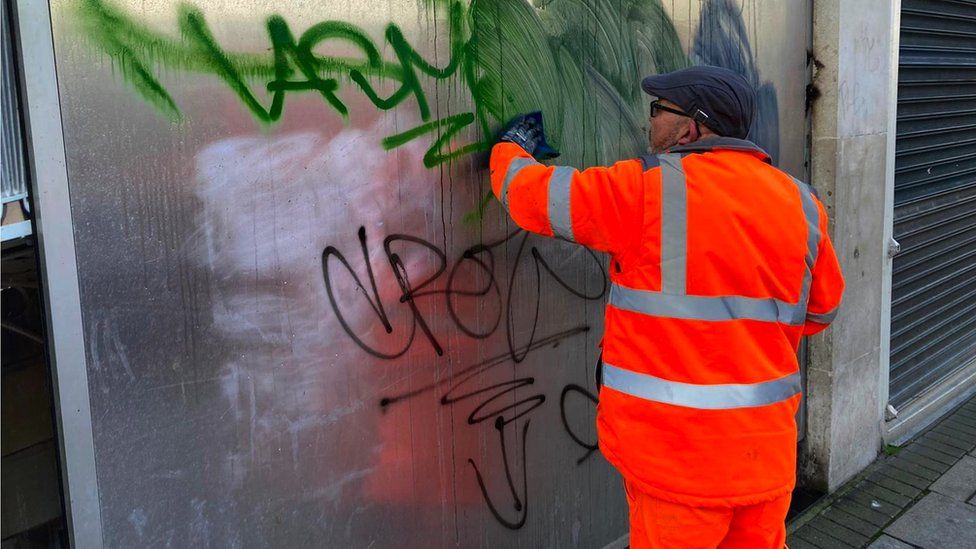 Workers remove graffiti