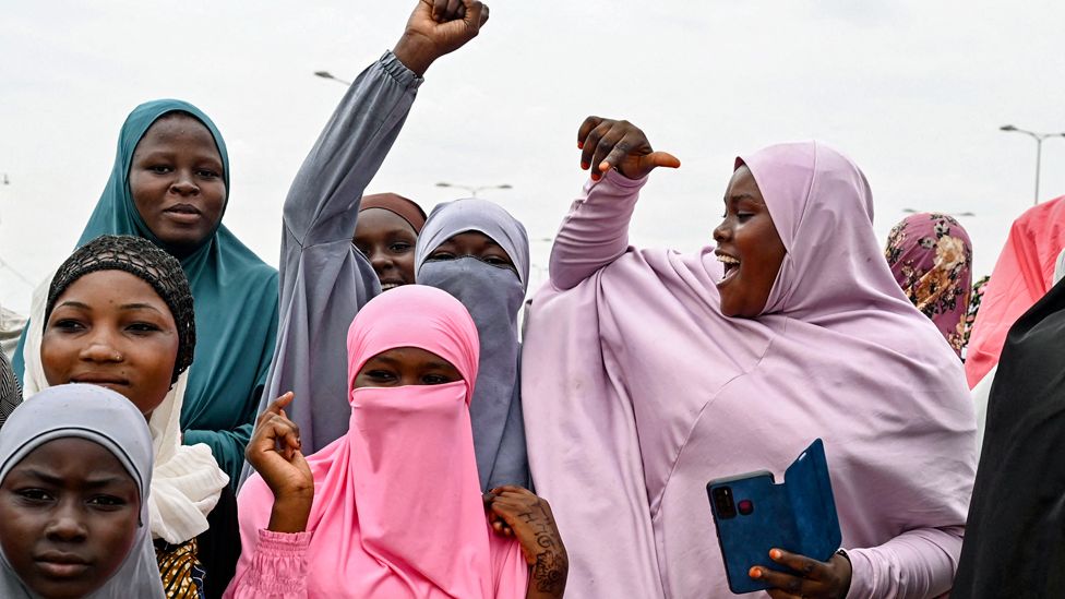 Female supporters fist pumping outside a French military base in Niamey, Niger - Friday 11 August 2023