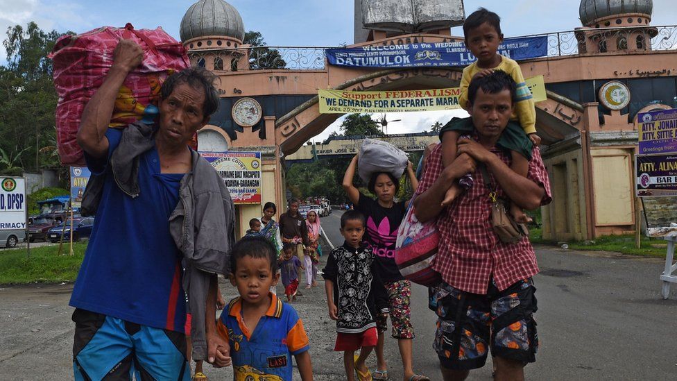 A family carrying their belongings flee from Marawi on the southern island of Mindanao