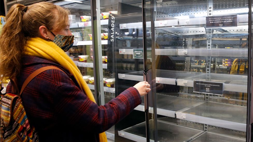 A customer wearing a protective face mask looks at empty shelves inside a Marks & Spencer food store on 6 January 2021 in Paris, France
