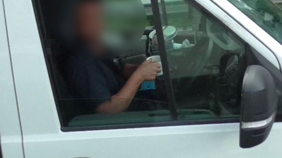 A driver drinking a cup of tea at the wheel on the M6