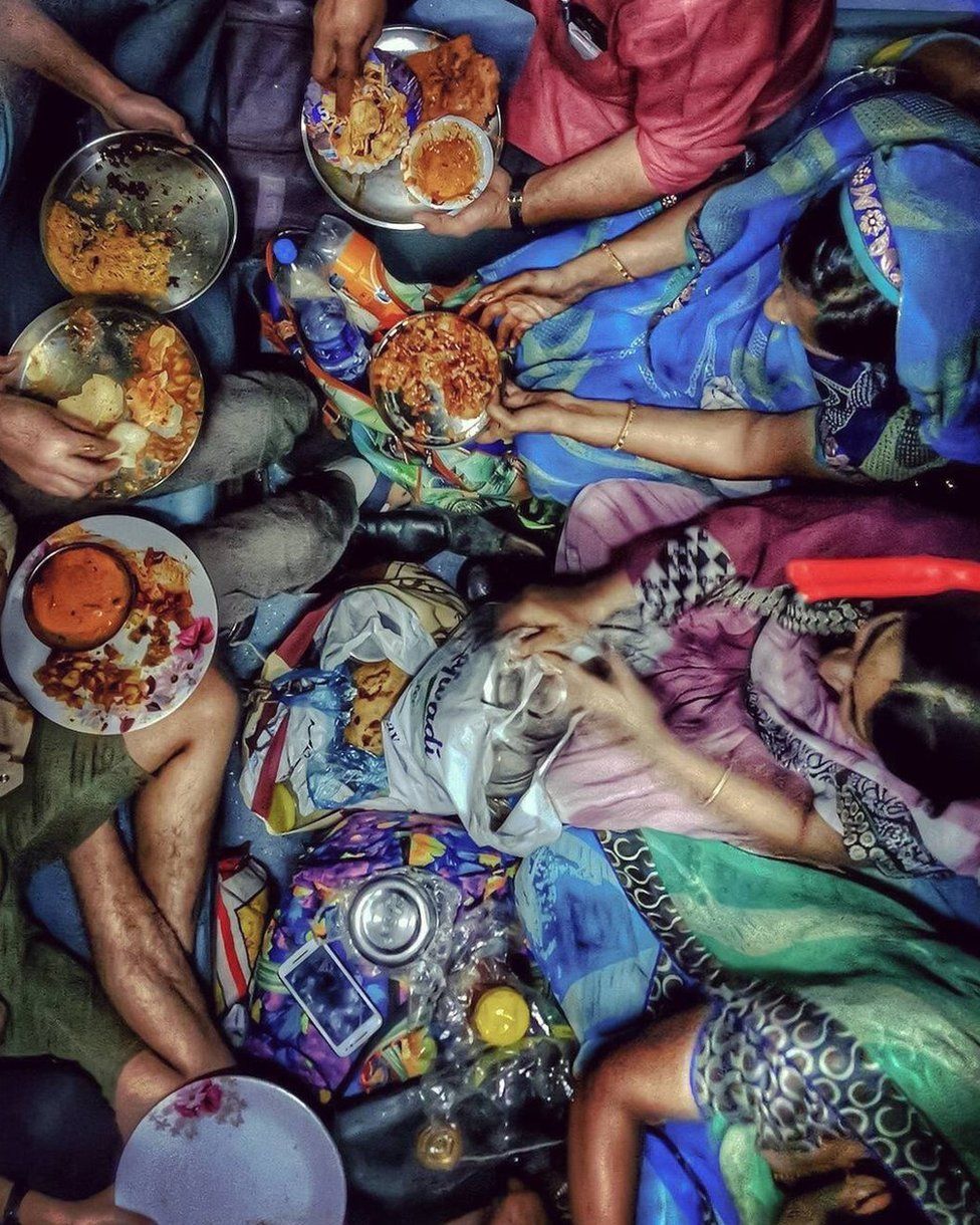 A family feasts on roti, rice and curries on a train.