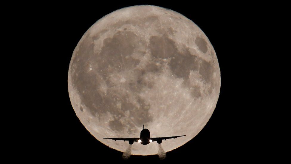 An aeroplane seen in front of the moon