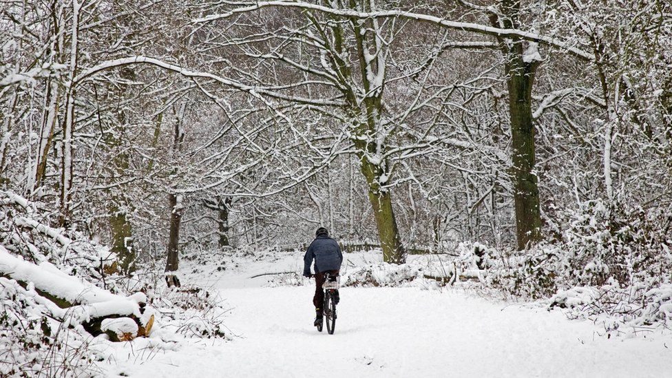 A man cycles across snow-covered Hampstead Heath in 2008