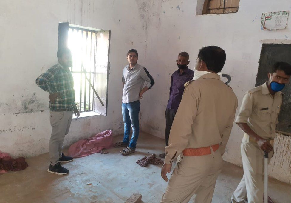 Police inspect the broken window at a quarantine centre in Bulandshahar district in Uttar Pradesh from where 16 people escaped