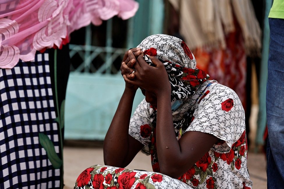 Kaba, a mother of a 10-day-old baby, reacts as she sits outside the hospital on 26 May.