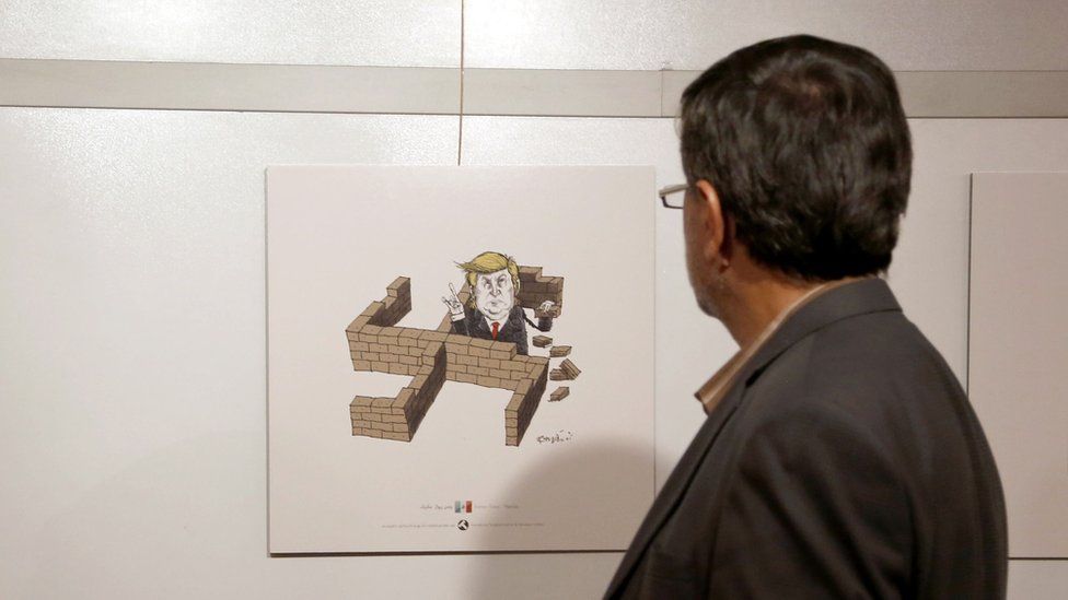 An Iranian man looks at cartoons of US President Donald Trump at an exhibition of the Islamic Republic's 2017 International Trumpism cartoon and caricature contest, in the capital Tehran on 3 July 2017