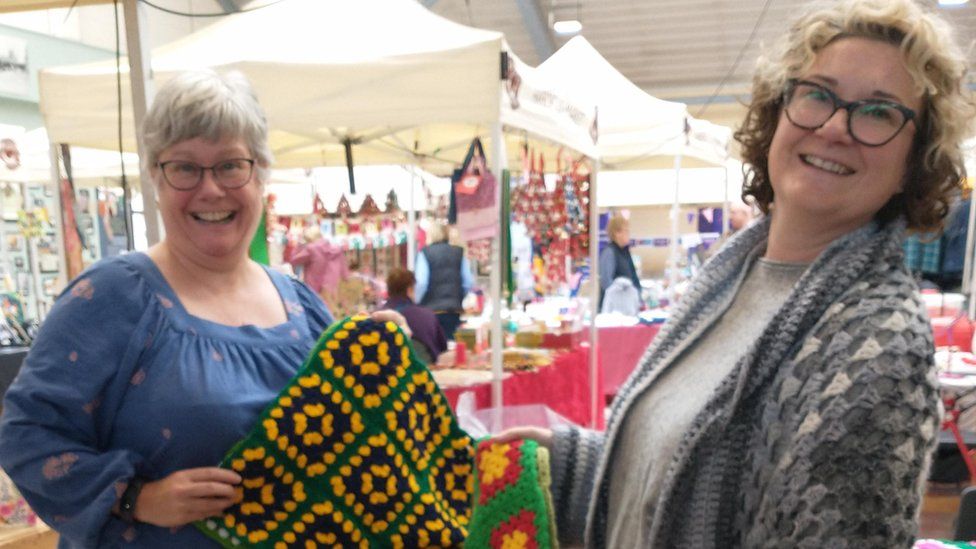 Crochet volunteers hold material