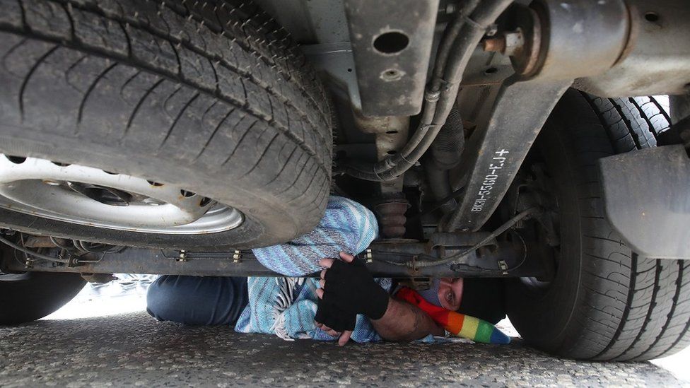 Man under immigration van