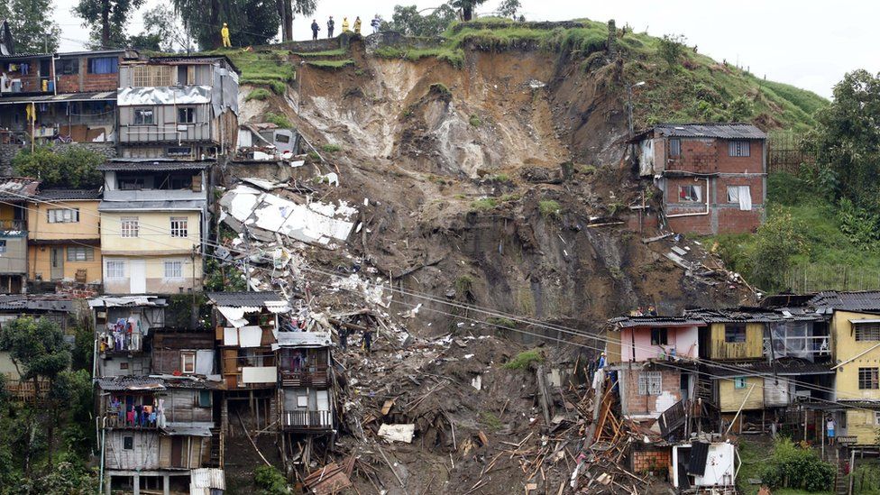 Rescue workers survey an area where a landslide destroyed several homes in Manizales, Caldas, Colombia