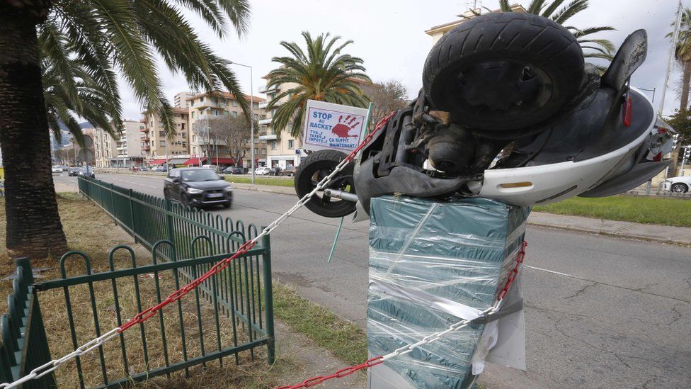A motorbike is perched atop a plastic-wrapped speed camera in Ajaccio on the French Mediterranean Island of Corsica, on December 2, 2018,