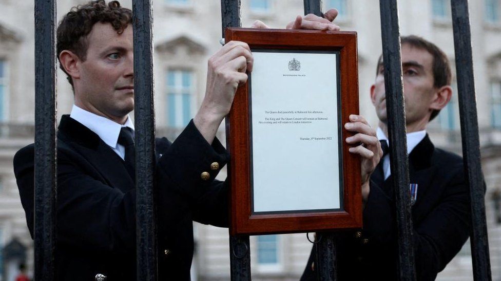Funcionários do Palácio de Buckingham colocam o aviso oficial da morte da rainha fora do palácio