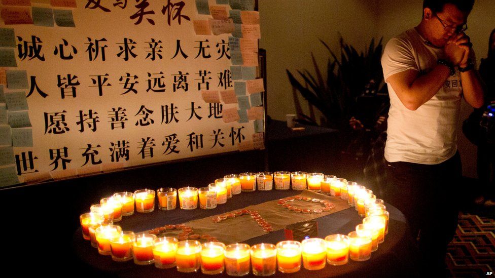 A relative of a Chinese passenger on board MH370 prays near candles before a briefing with Malaysian officials at a hotel in Beijing, China (March 31, 2014)