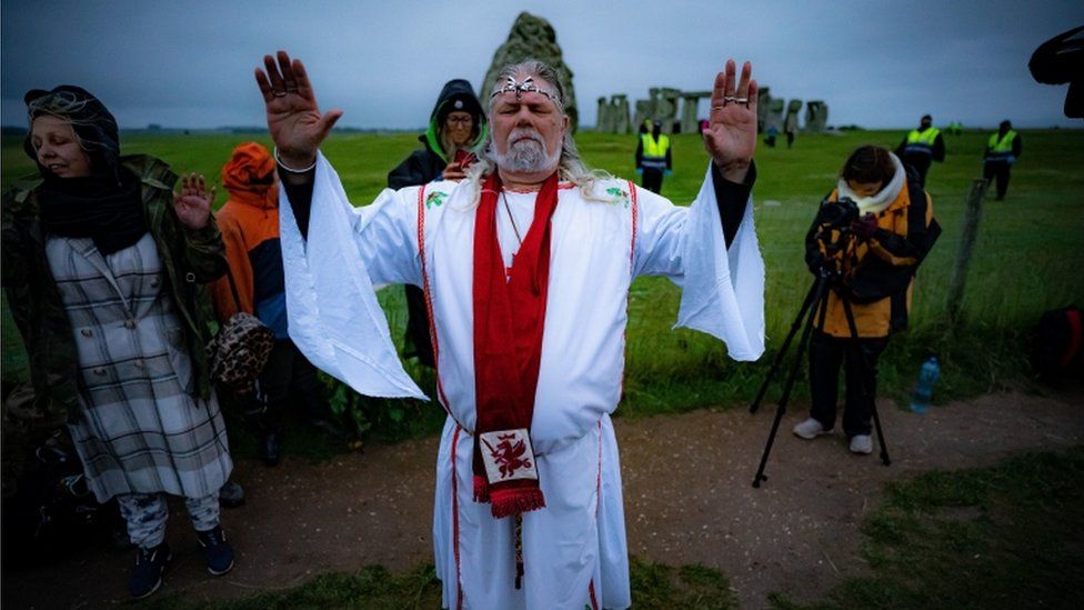 Arthur Uther Pendragon performs a ritual during summer solstice at Stonehenge, where people watch the sun rise at dawn of the longest day in the UK