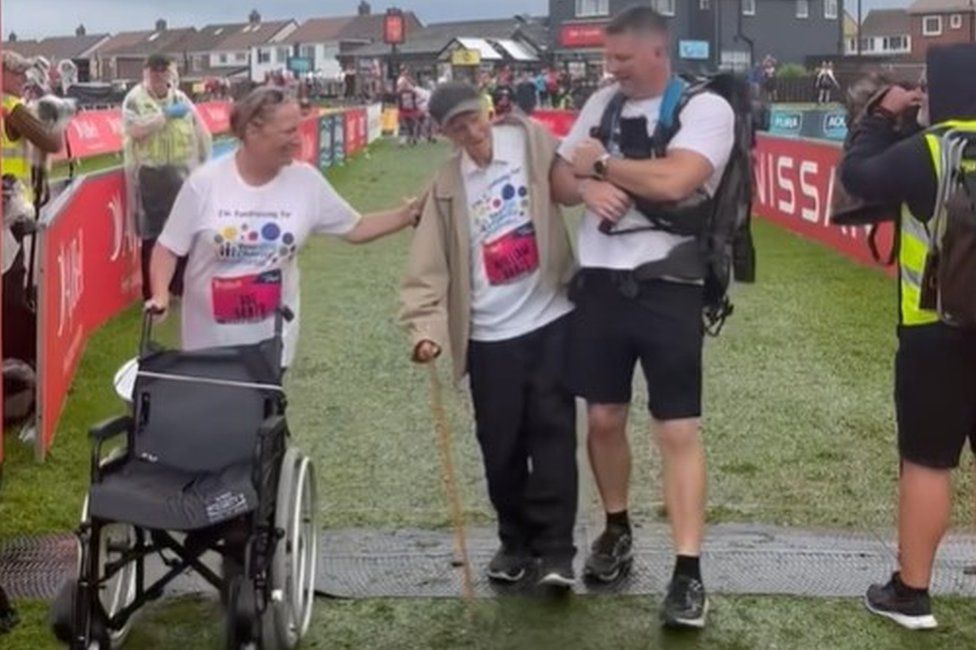 Bill crossing the finish line with two friends