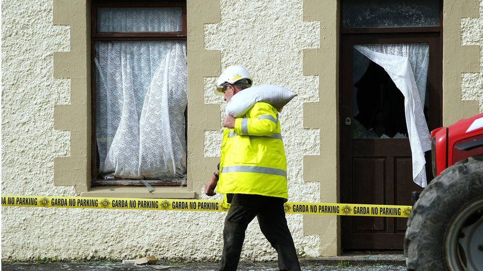 A man passes by damaged buildings close to the scene of the explosion
