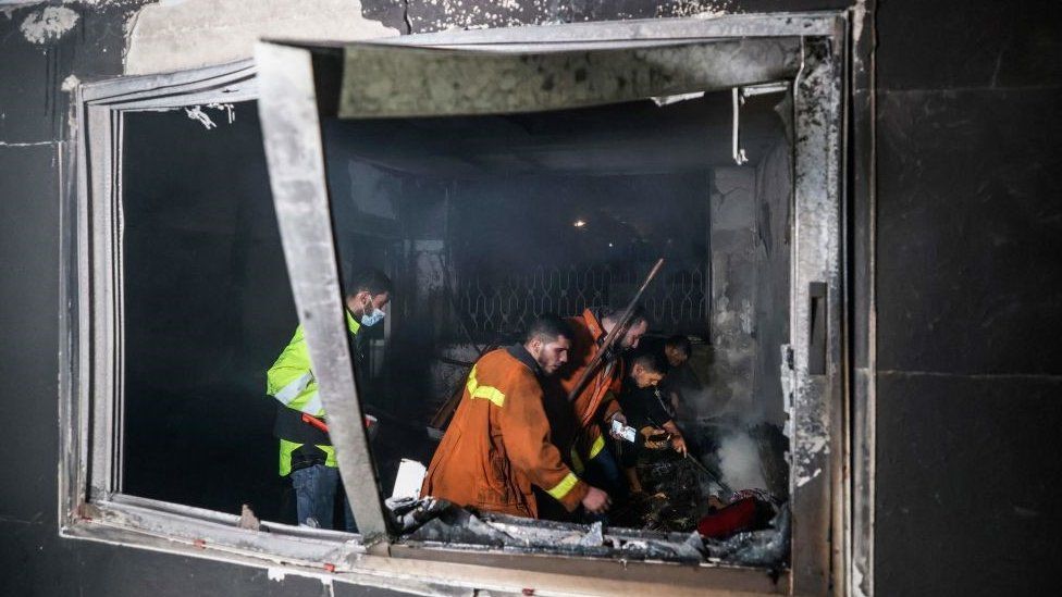 Palestinian firefighters extinguish flames in an apartment ravaged by fire in the Jabalia refugee camp in the northern Gaza strip, on November 17, 2022