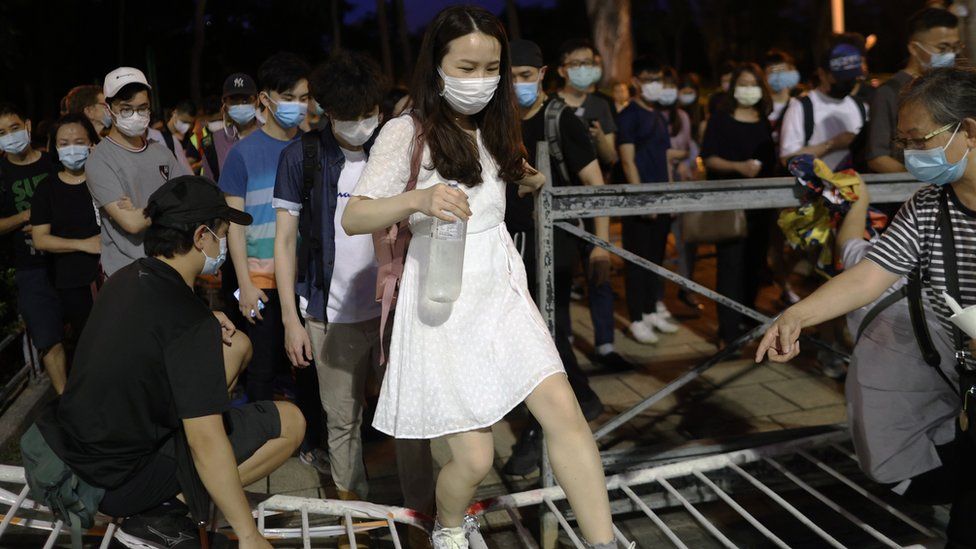 woman walks over barrier to prevent Tiananmen vigil in HK