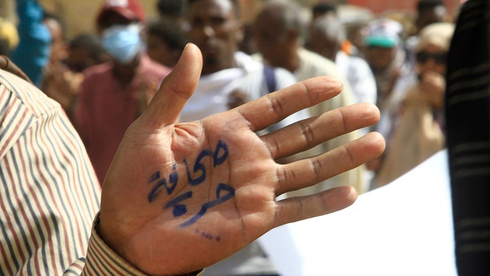 A man holding up his hand with the words "free press" written in Arabic in Khartoum, Sudan - Wednesday 8 February 2023