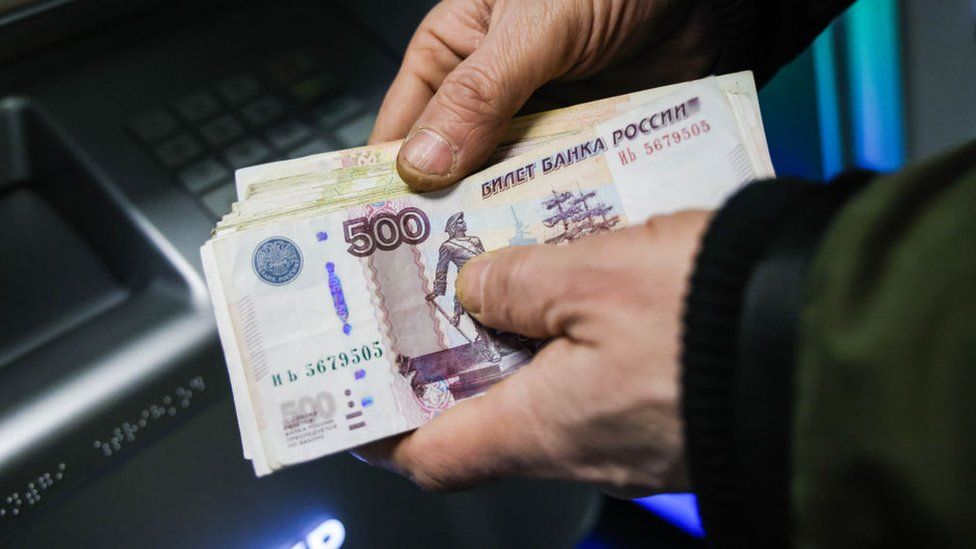 Person holding cash withdrawn from a Sberbank ATM