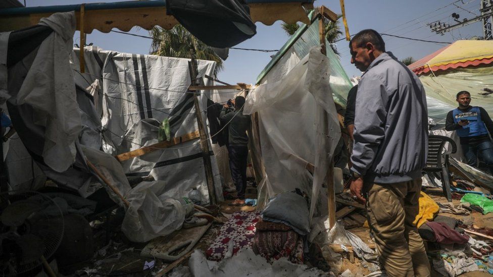 Palestinians inspect destroyed shelter tents following an Israeli air strike near al-Aqsa hospital