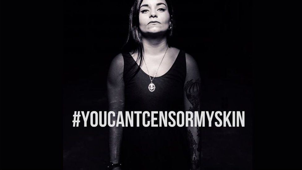 A woman with scars on her arms standing behind the hashtag #youcantcensormyskin