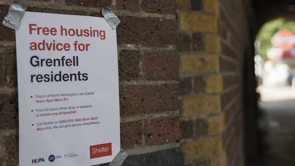 a post on a wall reads 'free housing advice for grenfell residents'