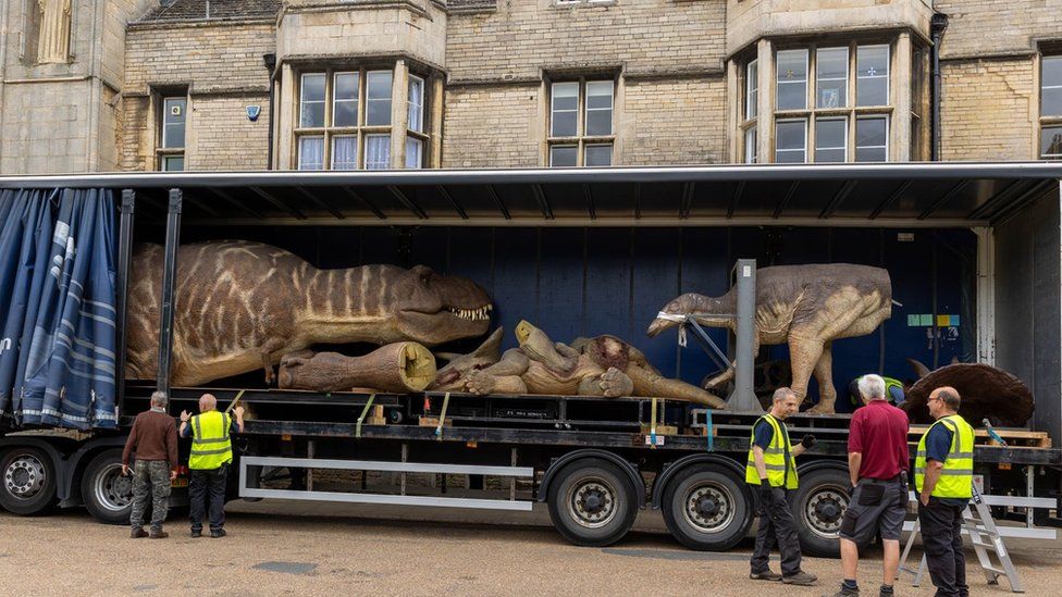 Model dinosaurs in lorry outside Peterborough Cathedral