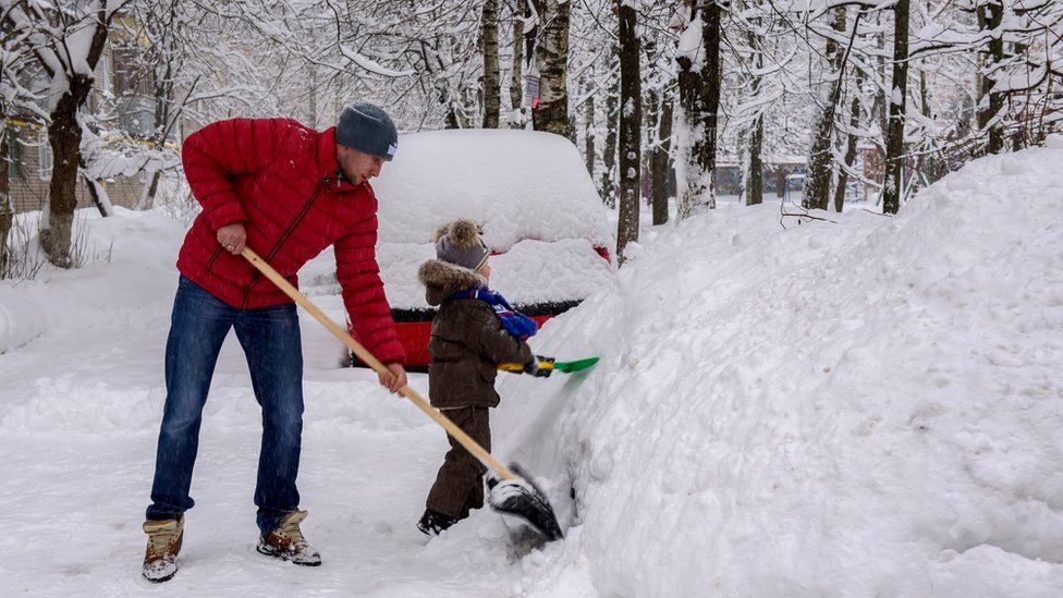 A man and boy shovelling snow