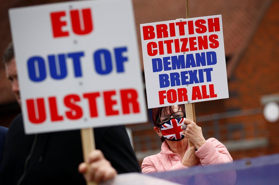 Unionist protesters hold signs which read: "EU out of Ulster" and "British citizens demand Brexit for all"