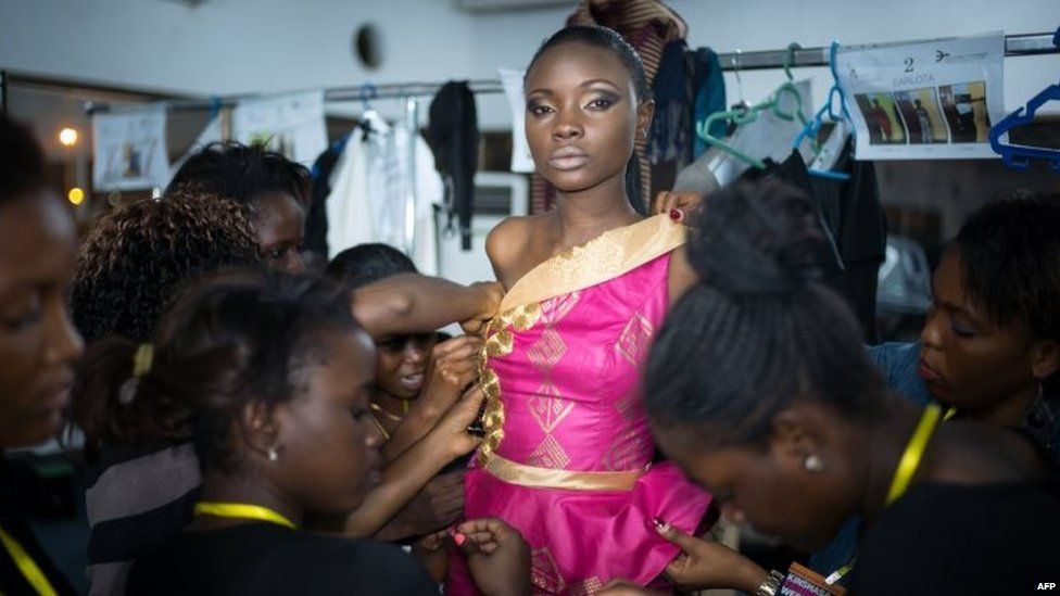 A model gets her dress fixed by seamstresses during the Kinshasa fashion week in Kinshasa, DR Congo - 24 July 2015