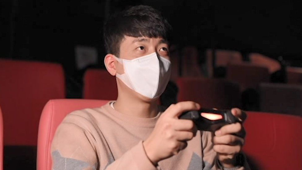 A man playing computer games in a CGV cinema