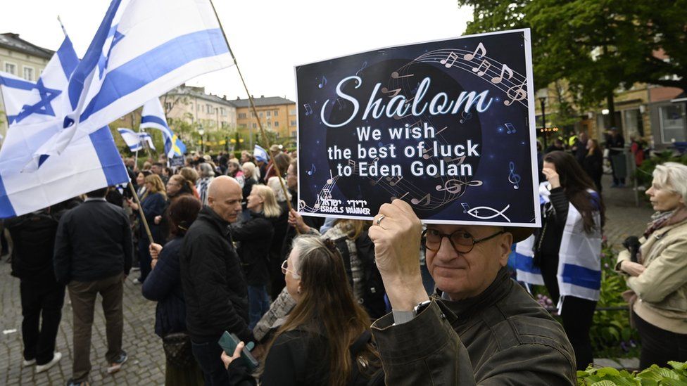 A man holds up a sign in support of Eden Golan