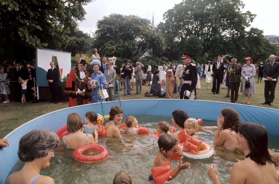 Queen Elizabeth II watches bathers in a pool at Parade Gardens, Bath, during her Silver Jubilee tour of Great Britain.